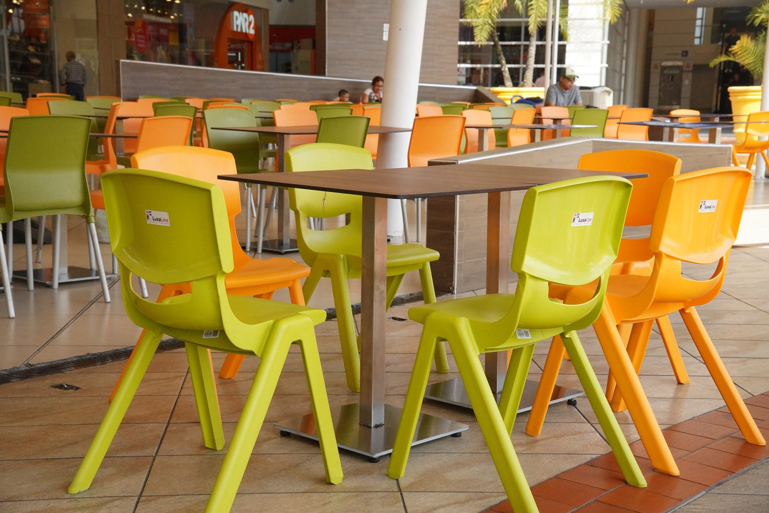 Food court con mesas y sillas de colores instaladas por ConstruMarket